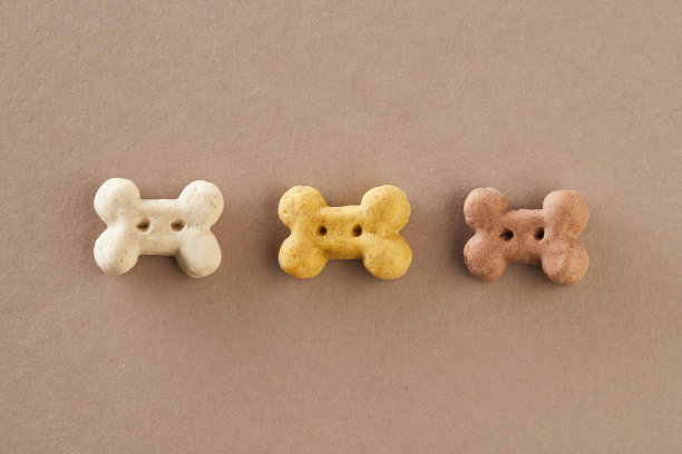 关闭干狗粮在棕色背景图片下载