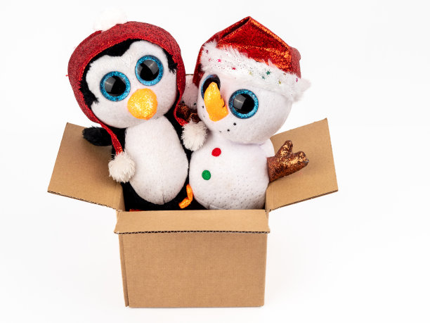 白色背景的纸板箱里的毛绒圣诞玩具。图片下载