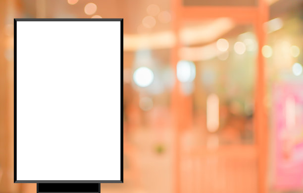 模型白色海报与黑色框架站在前面模糊百货商场的背景显示或目前的促销产品概念图片下载