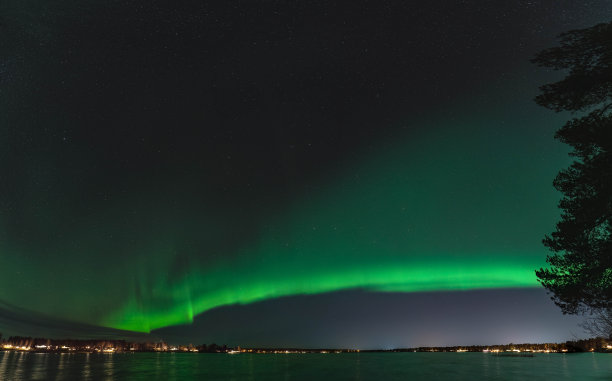 风景优美的极光全景图，宁静的夜晚，瑞典北部的于默奥市斯托克瑟湖上的北极光。水面的极光反射。星空的夜晚照片。图片下载