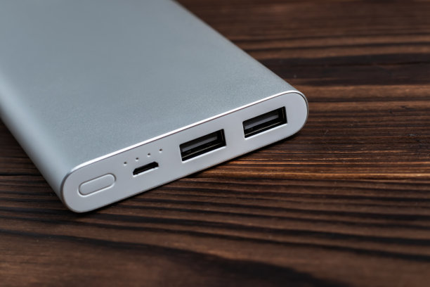 木制背景的移动设备充电宝。电池银行。移动设备的外部电池。图片下载