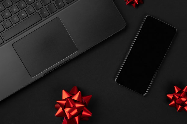 平板俯视图构图笔记本电脑，智能手机和弓。黑色星期五的促销模型图片下载