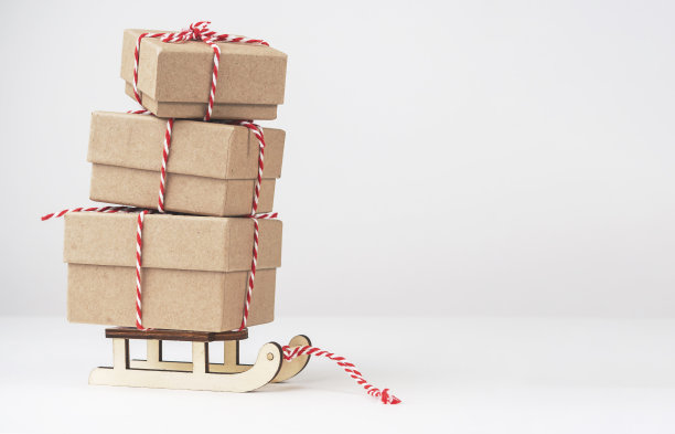 盒子上的礼物在一个浅背景的雪橇与空间的文字。新年和圣诞节的礼物。图片下载