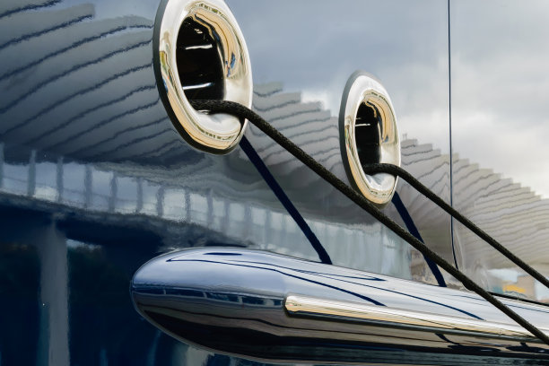 一艘豪华游艇的侧面特写，黑色系泊绳穿过圆形窗户图片下载