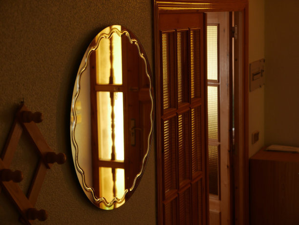 一面镜子映照着一扇棕色的门旁边的室内图片下载