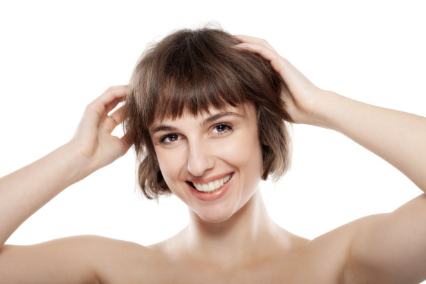 一个美丽的黑发女孩与短发孤立在白色背景的工作室肖像。图片下载