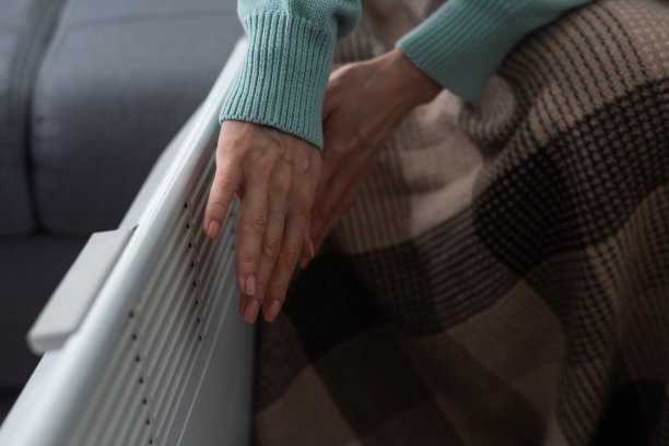 特写，妇女在家里的电加热器附近暖手图片下载