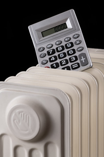 关于供暖价格的概念图，黑色背景上有计算器和电暖气片图片下载
