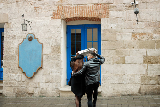 11月2日，在乌克兰利沃夫，一对夫妇用报纸遮雨。图片下载