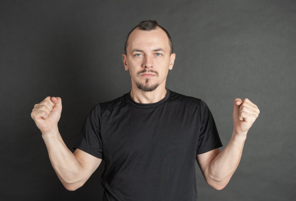 年轻英俊的男子准备用拳头举起的姿势打架图片下载