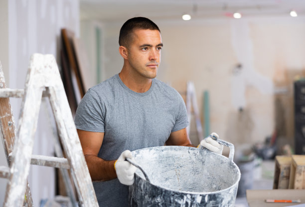 男子提着水桶在公寓工作，维修工作图片下载