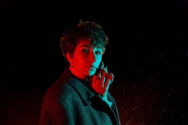 被冻住的白人妇女，披着外套，站在夜晚的街道上摆姿势图片下载