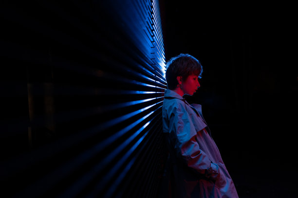 被蓝色霓虹灯照亮的忧郁女性的侧视图。心理健康,孤独。图片下载