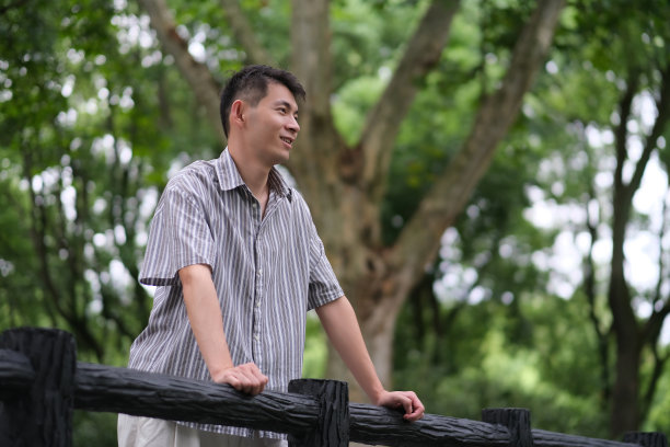 在户外绿色森林公园微笑的亚洲年轻人图片下载