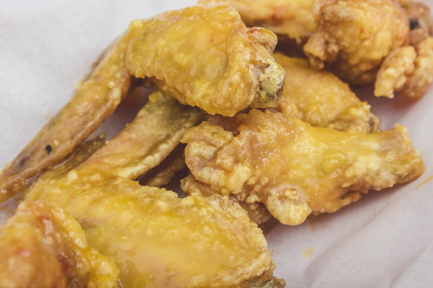 餐厅里的一份柠檬橙釉鸡翅。放在盖着防油纸的托盘上。图片下载