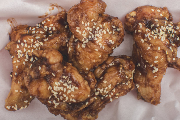 餐馆里的辣韩式鸡翅。放在盖着防油纸的托盘上。图片下载