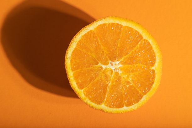 成熟的切橙在橙色柔和的背景。俯视图，近景，强光。图片下载