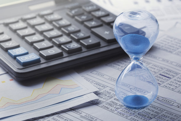 最好的投资时机。沙漏，财务图表和计算器。图片下载