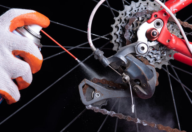 用喷油器清洁和上油自行车链条和齿轮。图片下载