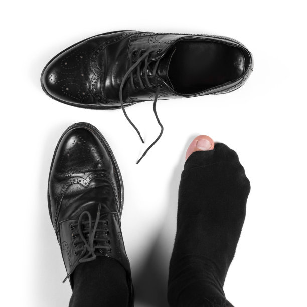 有洞的袜子和皮鞋。特写镜头。孤立在白色背景上图片下载