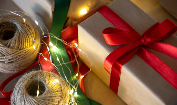 温馨的圣诞礼物手工纸盒与红色丝带蝴蝶结。除夕假期作文与礼品手工盒。圣诞节前夕的准备。家庭时光，温馨的家图片下载