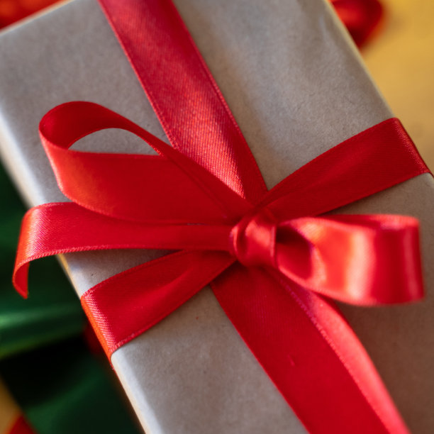 温馨的圣诞礼物手工纸盒与红色丝带蝴蝶结。除夕假期作文与礼品手工盒。圣诞节前夕的准备。家庭时光，温馨的家图片下载