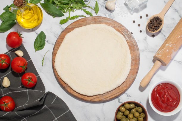 白色的烹饪背景与木板，面团和披萨配料。图片下载