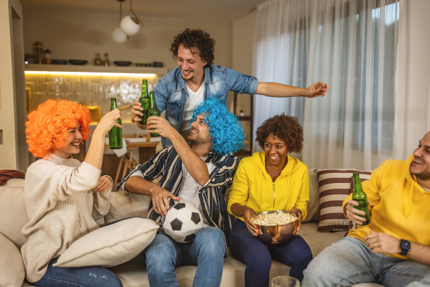 一群在电视上看足球比赛的朋友庆祝他们球队的胜利图片下载