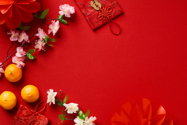 2023年兔年春节快乐。把红包、橘子、中国花卉和节日装饰平铺在红色的背景上。图片下载