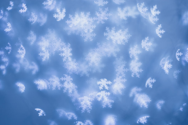 圣诞节或新年的抽象魔术灯背景，白色的雪花在蓝色的背景上散焦作为冬季的节日背景。圣诞心情唯美照片，效果模糊，庆典照明图片下载