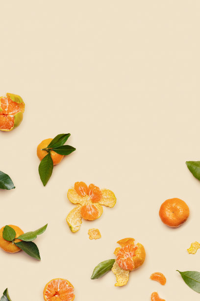 成熟新鲜的橙黄色橘子，绿色的叶子，整个去皮，米色的背景和副本空间。柑橘、水果、橘子、静物美学照片，创意布局，垂直图片下载