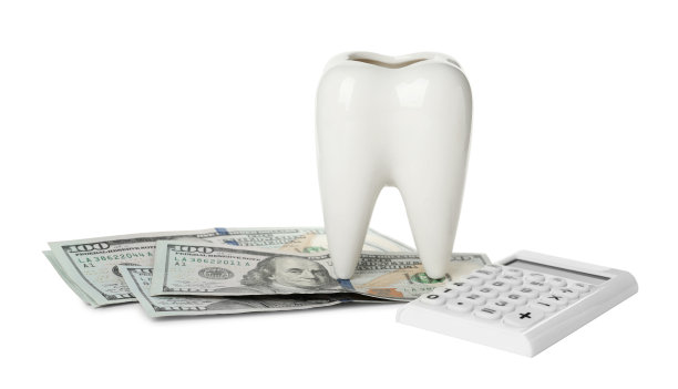 白色背景的陶瓷牙齿，计算器和美元钞票模型。昂贵的治疗图片下载