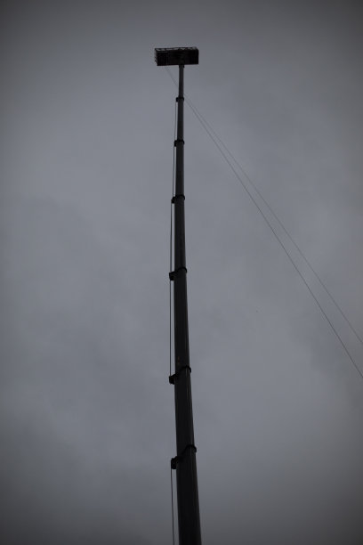 伸缩式升降到高度。高空工作。平台在高柱子上。图片下载