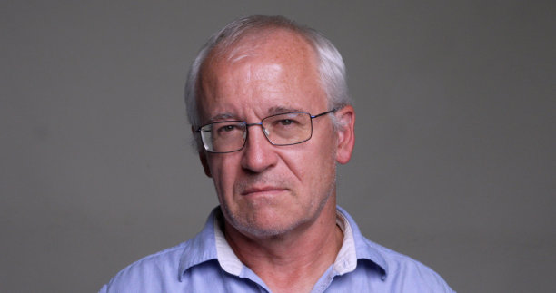 严肃的男人看着灰色背景上的相机图片下载