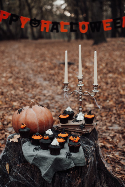 万圣节纸杯蛋糕和节日装饰在枫叶树在秋天的户外图片下载