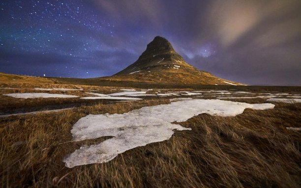 美丽的照片，干燥的草地上有雪片和远处的山图片下载