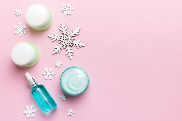 彩妆产品和圣诞装饰的彩色背景。顶视图新年美景概念与复制空间图片下载