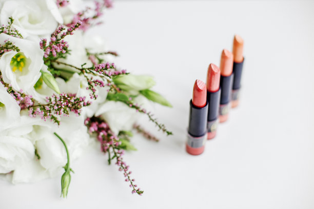 一套彩色口红。化妆品和护理的概念。美丽的花朵。本空间图片下载