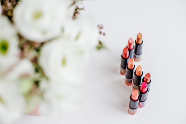 一套彩色口红。化妆品和护理的概念。美丽的花朵。本空间图片下载