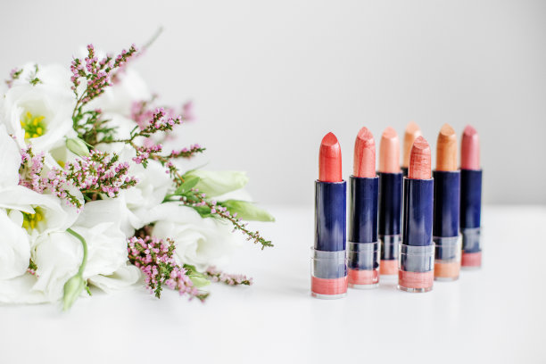 一套彩色口红。化妆品和护理的概念。美丽的花朵。本空间图片下载