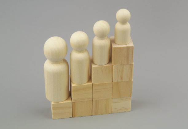 在事业和政治观念上贬低人。不同的木制人物在楼梯上的立方体木制。图片下载