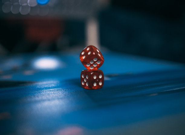 红色骰子放在蓝色表面上的特写镜头图片下载