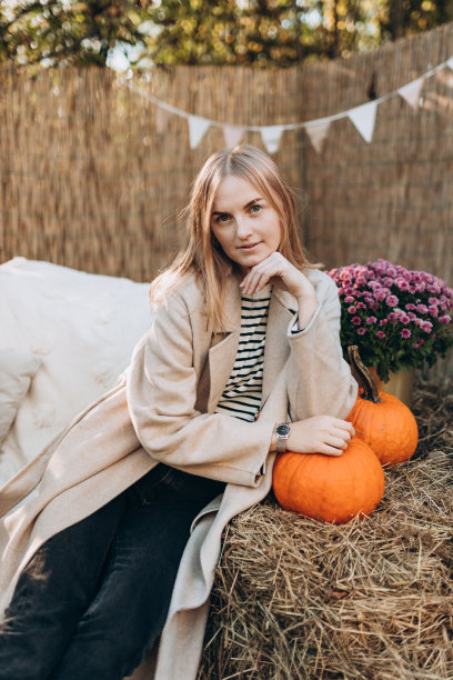 时髦的金发女人穿着自然背景的外套。秋季户外的优雅。潮流女装，秋季时尚收藏。图片下载