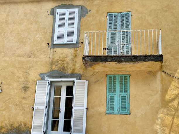 典型的科西嘉建筑立面。带铜绿的黄墙，木百叶窗，阳台。图片下载