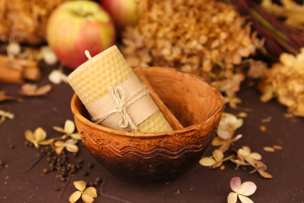 手工蜂蜡蜡烛，碗，苹果和干绣球花在棕色的背景。蜂蜜秋天舒适的香气为室内和传统。模型,前视图。图片下载