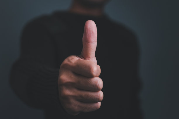 经营理念与满意度调查。一个男性顾客的大拇指在屏幕上显示了一个伟大的标志。图片下载