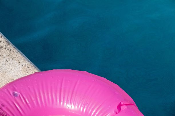 粉红色的浮在游泳池的边缘图片下载