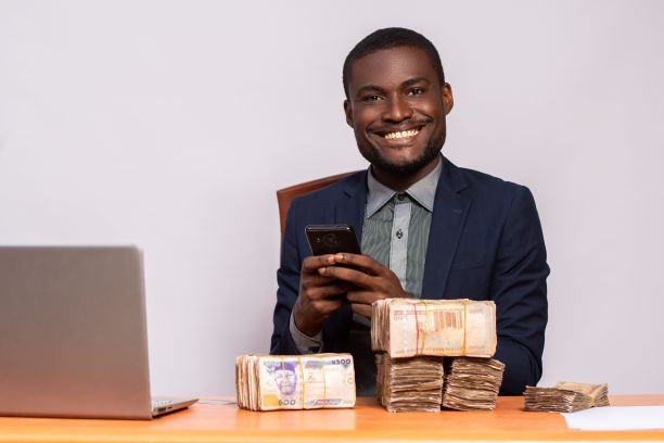 快乐的非洲商人有一大堆钱，脸上带着快乐的微笑，给家人发短信图片下载