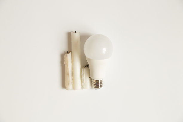 白色背景的Led灯泡和蜡烛，电力和储蓄的选择图片下载