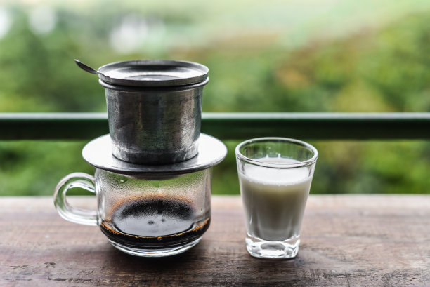 越南传统咖啡加牛奶，放在木桌上图片下载